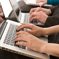 Business people using laptops to make notes isolated on white