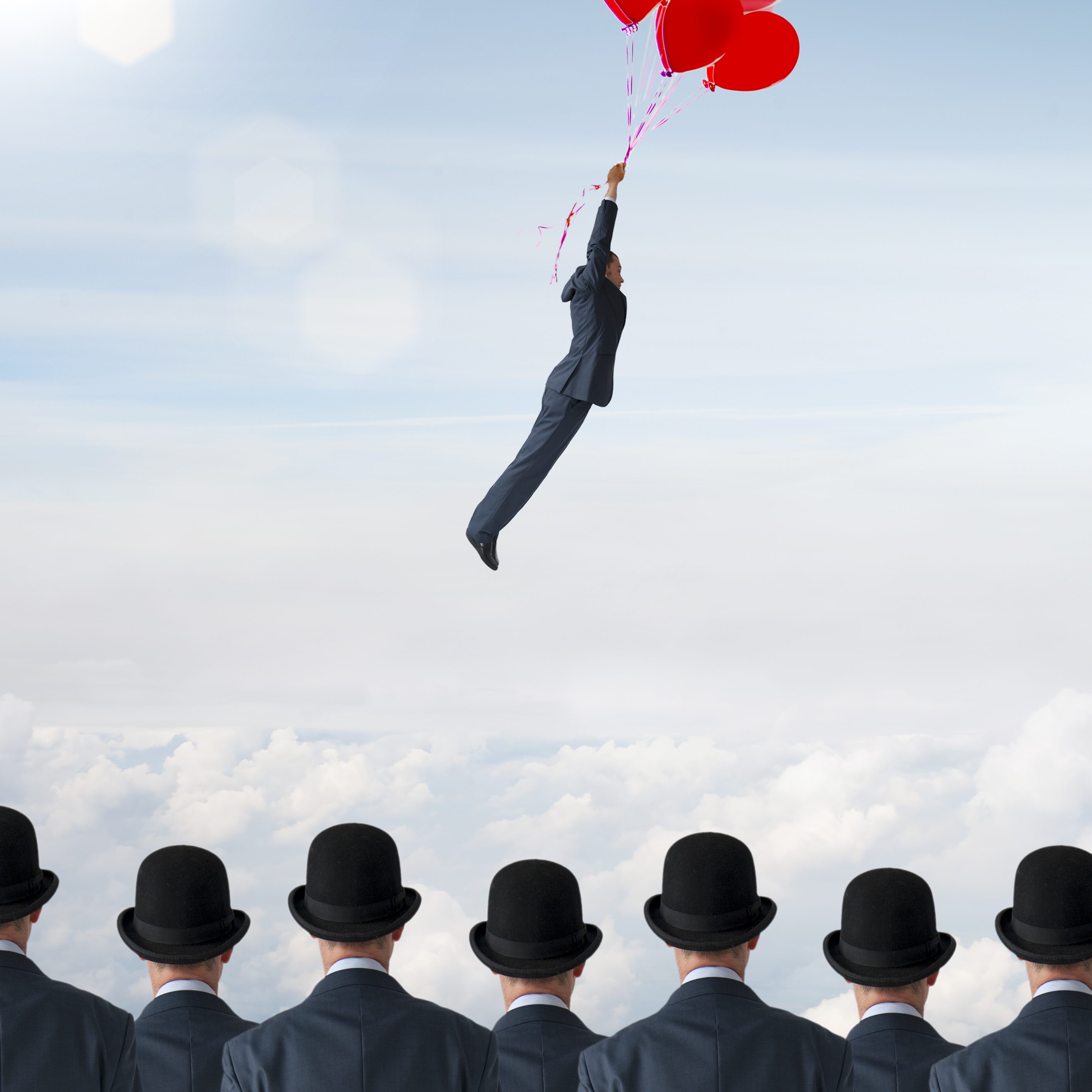 business individuality concept businessman flying away from crowd with balloons