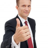 Portrait of young happy business man showing thumb's up sign. Approval, good work, and success.